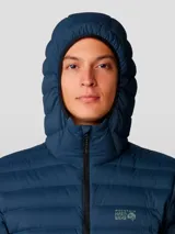 Campera negra con capucha, rellena de plumón de 650 cuins. Confeccionada en tejido Pertex® Quantum resistente al agua. Cuenta con cierre frontal, bolsillos laterales con cierre y un bolsillo en el pecho con cierre. Se puede guardar en su propio bolsillo.