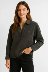 Blusa de jean gris lavado, de corte holgado, con cuello camisero, manga larga y bolsillo en el pecho.