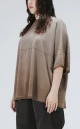 Remera de manga corta con calce extra oversize, color marrón chocolate con efecto gastado/deslavado. Presenta un corte con recortes horizontales en el frente y la espalda, y cuello redondo con terminación deshilachada.
