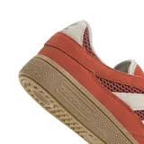 Zapatillas Adidas Handball Spezial color naranja con detalles en blanco y suela color caramelo.