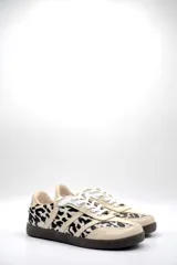 Zapatillas Adidas Samba con estampado animal print en blanco y negro, detalles en cuero beige y suela de goma color caramelo.