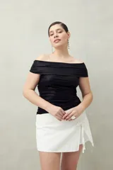 Top negro con escote off-shoulder, confeccionado en tejido de punto con efecto satinado y corte ajustado.