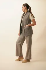 Chaleco color beige, entallado, con solapa, bolsillos plaqué y terminaciones envivadas.