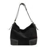 Bolso tipo hobo o tote de eco cuero con textura símil gamuza en color negro. Presenta detalles de pespuntes en color blanco en la base, que es de cuero liso negro. Tiene correa de hombro delgada y ajustable.