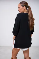 Sweater negro de punto con cuello redondo, mangas largas y corte holgado.