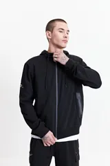 Campera negra con capucha y cierre frontal, de felpa sin frisa, con bolsillos laterales con cierre y logo estampado en relieve en el pecho.