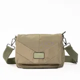 Bandolera verde de tela acolchada con diseño geométrico y correa de hombro ajustable.