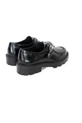 Mocasines negros de charol brillante con suela track robusta, antifaz y detalles metálicos.