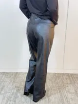Pantalón negro de eco cuero, corte recto y tiro alto.