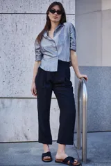 Pantalón de vestir negro de corte recto y tiro alto, con bolsillos laterales y cintura elástica.