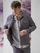 Camisa color verde militar de manga larga con cuello clásico, cierre frontal con botones y dos bolsillos de parche en el pecho.