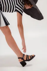 Sandalias de cuero marrón con múltiples tiras y hebilla lateral.