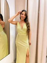 Vestido largo metalizado con escote en V, breteles finos y tajo profundo.