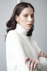 Polera de punto color crema con cuello alto y mangas largas.