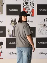 Remera de algodón gris oscuro, corte oversize, con cuello redondo y manga corta. Presenta un estampado frontal de Maléfica en tonos negro, morado y verde pálido.