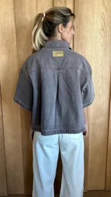 Sobrecamisa color gris oscuro de denim suave, con cuello clásico, cierre frontal con botones, mangas cortas y dos bolsillos de parche en el pecho.