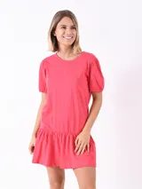 Vestido corto fucsia con mangas cortas abullonadas y falda con volantes.