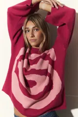 Sweater tejido de algodón color rosa y fucsia, con cuello redondo y diseño de espiral en el frente.