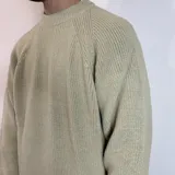 Sweater verde oliva de tejido grueso con cuello alto.