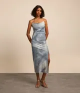 Vestido midi de tul con forro, estampado abstracto en tonos celeste y blanco, breteles finos cruzados en la espalda y corte al bies.