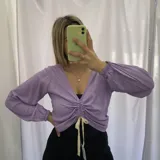 Remera de manga larga color lila con escote en V y frunce central ajustable con cordones.