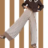 Pantalón de punto marrón con rayas verticales blancas, corte palazzo y cintura alta.