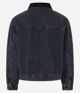 Campera trucker boxy de jeans gris con cuello de terciopelo negro, abotonada al frente, con bolsillos delanteros y mangas largas ajustadas.