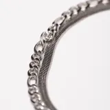 Pulsera plateada de acero con doble cadena, una de eslabones tipo fígaro y otra tipo serpiente.
