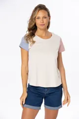 Remera de manga corta color beige con bloque de color en mangas: celeste en la manga izquierda y rosa en la manga derecha.