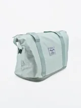 Bolso de viaje plegable color verde agua, con base gris y cierre superior.