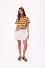 Falda corta de lino color rojo, con diseño de tiro alto y un volado en el ruedo. Posee cierre en la parte posterior.