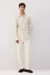 Camisa color crema en mezcla de lino y algodón, de corte regular fit, manga larga con puños abotonados, cuello inglés, tapeta clásica, canesú en la espalda, bolsillo superior abierto y bajo redondeado.