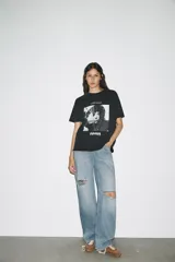 Remera negra de algodón con efecto lavado, cuello redondo y mangas cortas. Estampado frontal con imagen de Lady Gaga y texto "LVDY GAGA" y "MAYHEM".