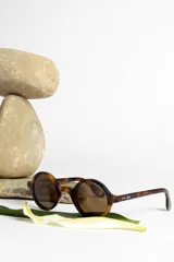 Lentes de sol con montura redonda negra y cristales verdes.