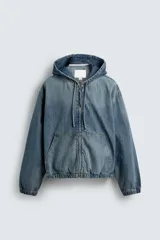 Cazadora relaxed fit de jean con capucha ajustable y cierre frontal de cremallera. Tiene bolsillos frontales tipo canguro y terminaciones con elástico. Presenta efecto lavado.