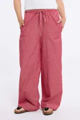 Pantalón de tela color rojo con rayas verticales blancas, corte ancho y cintura con cordón ajustable.