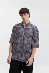 Camisa oversize de manga corta con estampado abstracto en tonos beige y blanco.