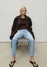 Jeans celeste de tiro alto, corte mom fit, con cinco bolsillos y cierre frontal con cremallera y botón.