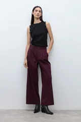 Pantalón de mujer color beige, tiro alto, con pliegues (pinzas) frontales y corte ancho y recto en las piernas.