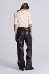 Pantalón recto de cuero sintético negro, estilo jeanero con tiro bajo, bolsillos delanteros y traseros, pretina con botón y pasacintos.