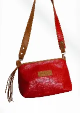Cartera tipo sobre color rojo con textura simil reptil, forrada en tela panamá. Tiene correa de cuero marrón removible y cierre superior.