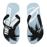 Chinelas de dedo con base celeste y estampado de palmeras y logo Mormaii en blanco y negro.