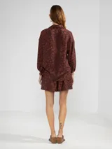 Short negro con estampado de aves blancas, cintura elastizada, pliegues al frente y bolsillos laterales.