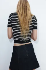 Remera corta de punto fino suave a rayas horizontales azul marino y blancas, con cuello redondo y mangas cortas.