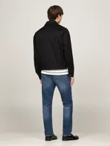 Campera negra Tommy Hilfiger de corte regular, confeccionada en puro algodón, con cuello inglés, cierre de cremallera, dos bolsillos diagonales en la cintura, un bolsillo interior abierto, puños con botón, forro completo y logo de Tommy Hilfiger bordado en el pecho.