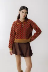 Sweater de punto con cuello polo, diseño de rombos en tonos marrón y ocre, y ribetes en color ocre.