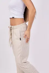 Pantalón capri a rayas verticales color verde y blanco, con cintura elástica y lazo ajustable.