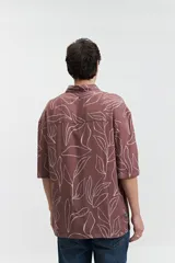 Camisa oversize de manga corta con estampado abstracto en tonos beige y blanco.