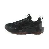 Championes negros de trail running New Balance, con suela marrón y detalles en gris.