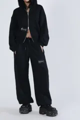 Campera negra con cierre frontal, capucha y logo de la marca en el pecho.